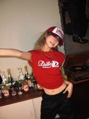 Back and side view of a red women's cropped streetwear T-shirt with fitted silhouette, trucker hat, and layered silver necklaces