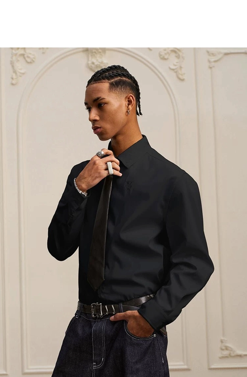 Relaxed black baroque embroidered shirt styled with black necktie, leather belt, and dark belted jeans