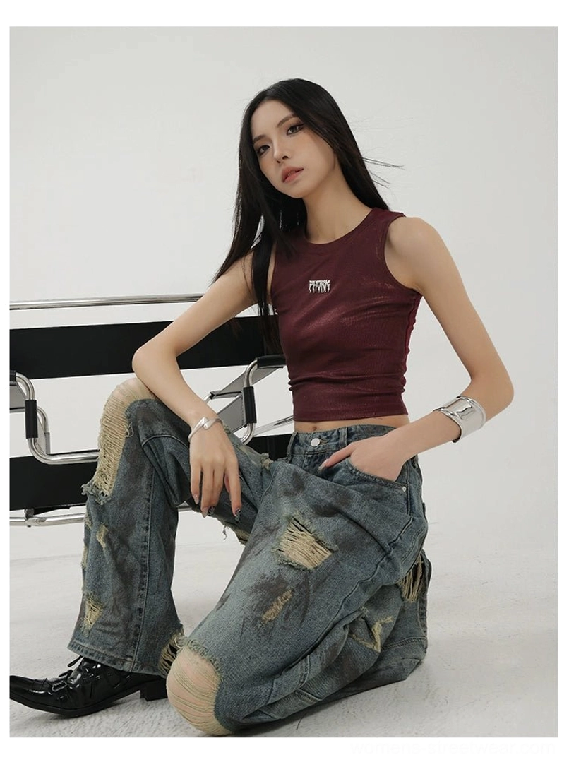 Seated floor view of women's relaxed blue distressed jeans with frayed ripped knee and thigh details