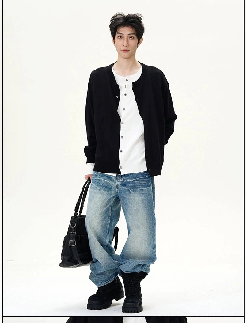 Male model in a black cardigan wearing relaxed blue wide-leg denim jeans with a faded vintage finish