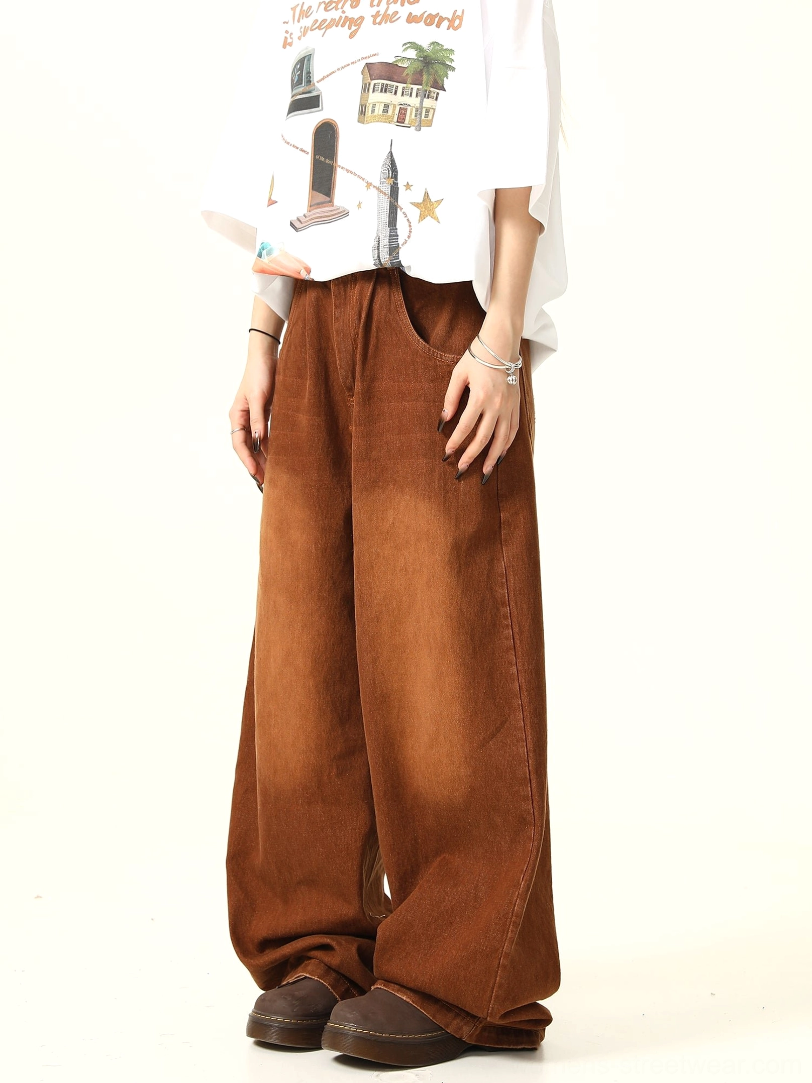 Side three-quarter view of relaxed brown vintage denim pants with a faded finish and full-length wide legs
