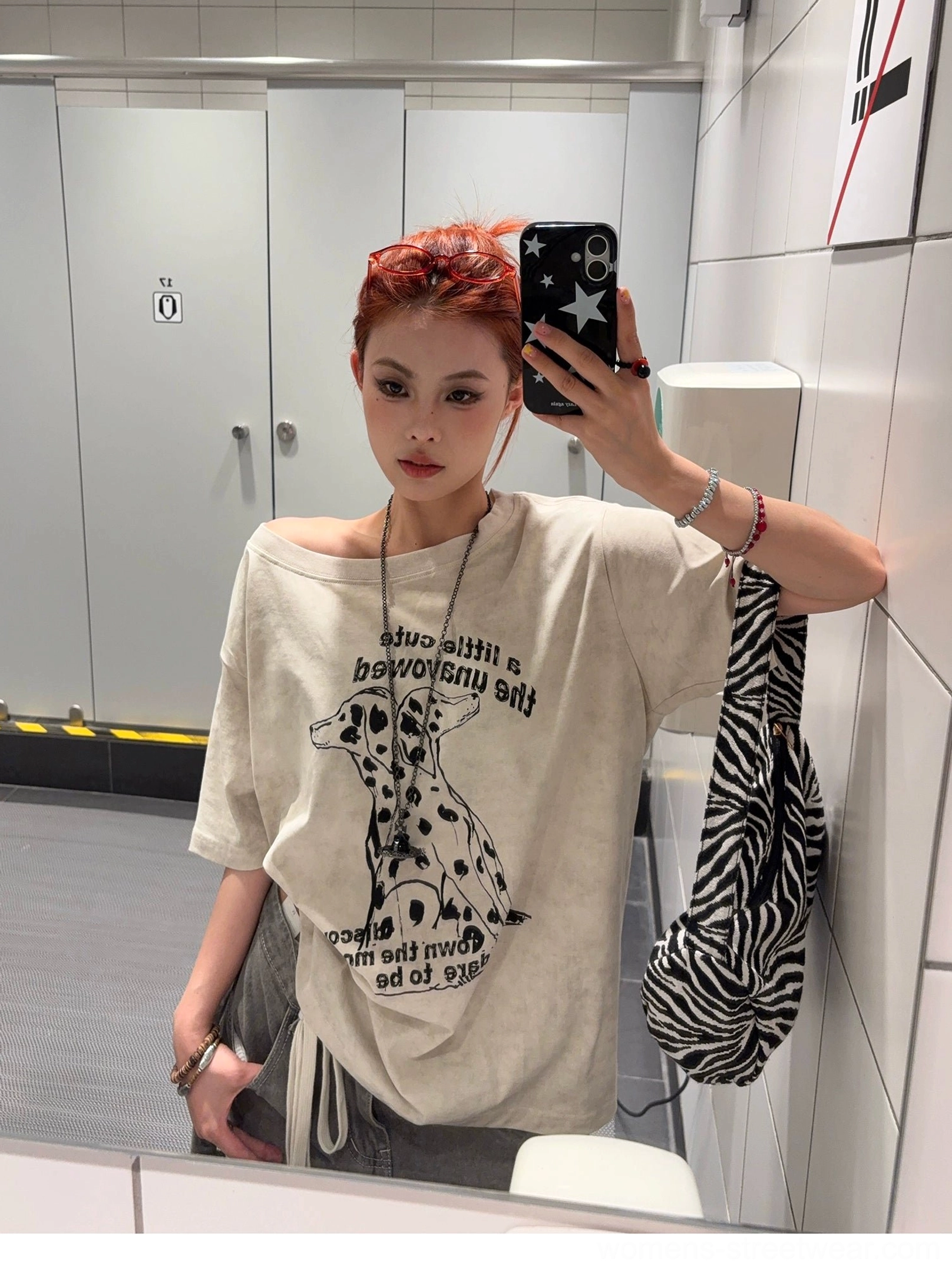 Side view of a relaxed Dalmatian dog graphic oversized T-shirt in faded apricot fabric styled with a zebra-patterned crossbody bag