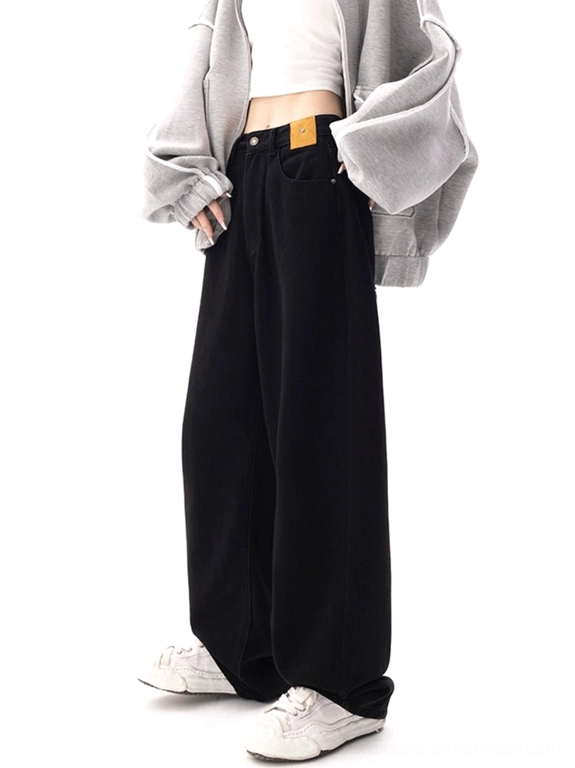 Relaxed dark blue wide-leg streetwear jeans shown from a side angle with practical pockets, loose legs, and a full-length denim silhouette