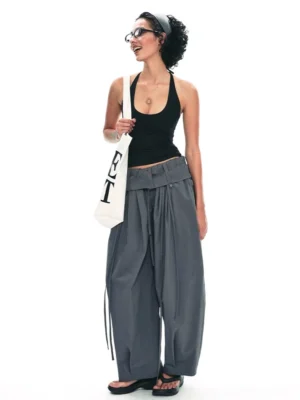 Dark gray relaxed drawstring paperbag wide-leg streetwear trousers styled with black tank top and canvas tote front three-quarter view
