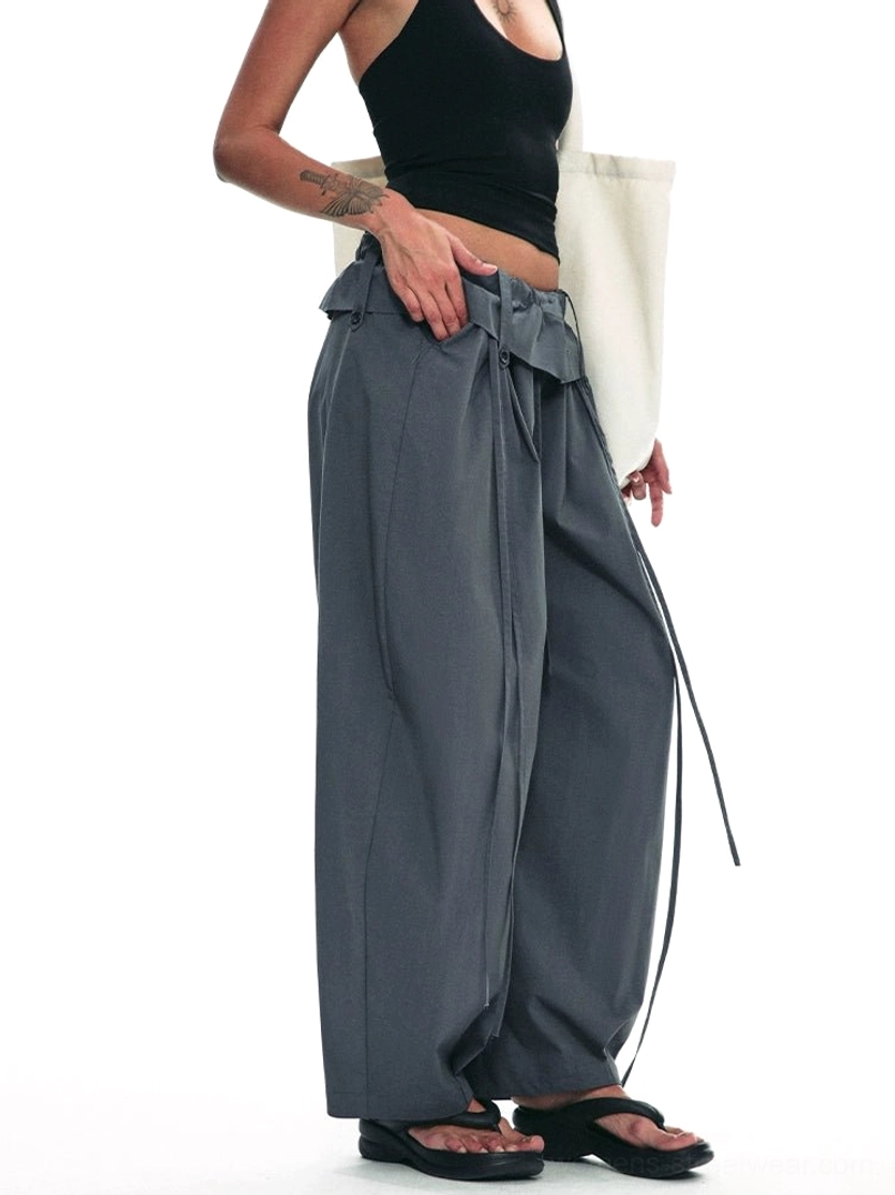 Dark gray paperbag wide-leg trousers side three-quarter view showing fold-over drawstring waist and oversized streetwear fit