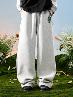 Light gray relaxed drawstring wide-leg sweatpants shown from the front in an outdoor minimal streetwear outfit
