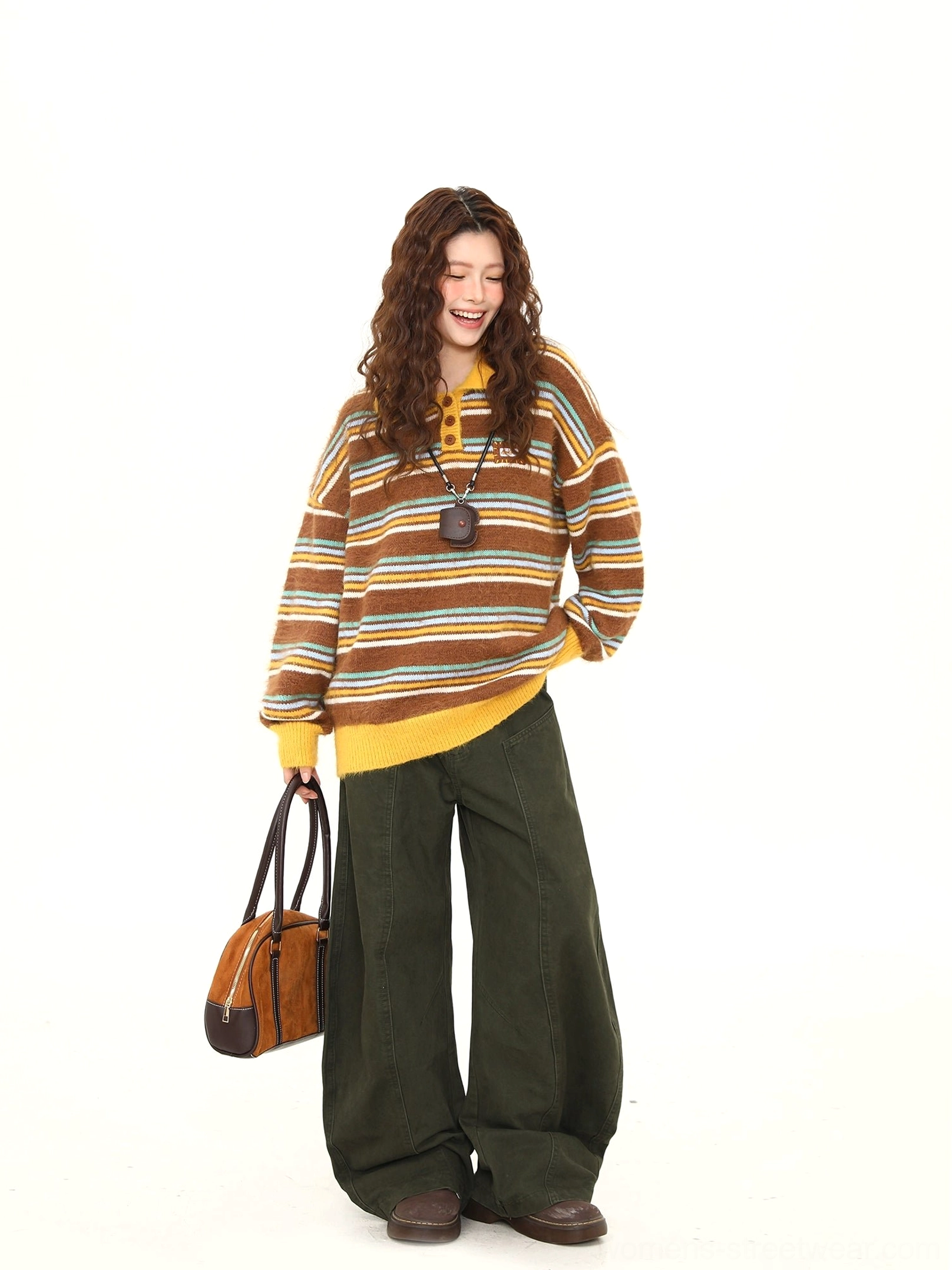 Side view of a relaxed fit retro striped fuzzy knit sweater with contrast collar and cuffs styled with wide-leg pants and vintage handbag