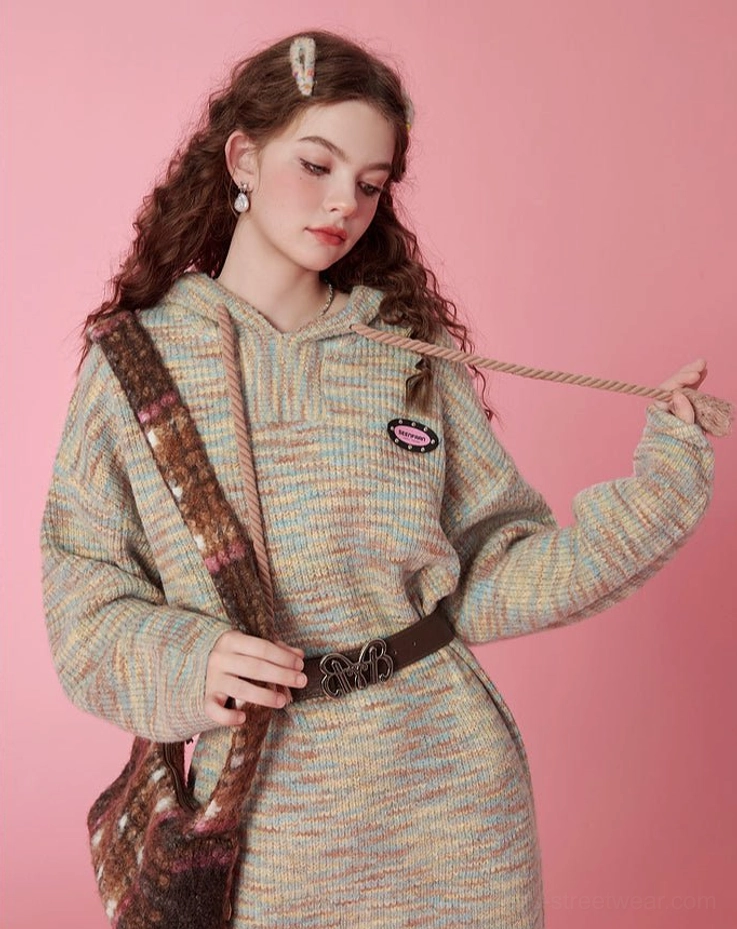 Side three-quarter view of a relaxed hooded space-dyed knit midi dress with long sleeves and casual oversized streetwear proportions