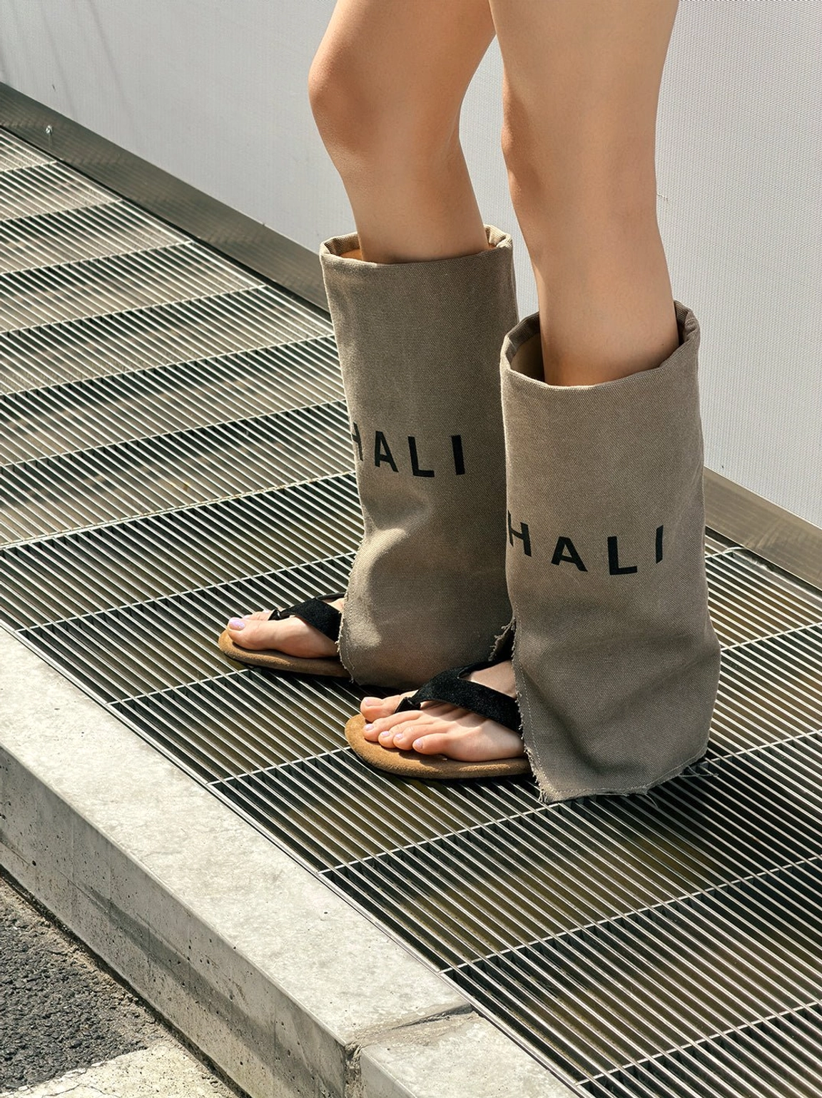 Relaxed khaki western sandal boots featuring split-toe construction, black thong strap, suede footbed, and mid-calf shaft