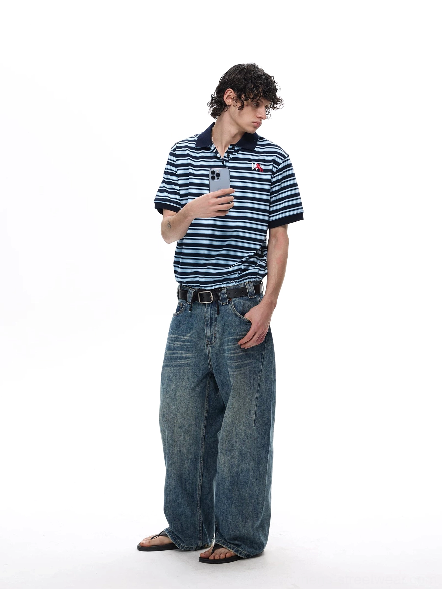Relaxed fit navy blue striped polo shirt with contrast collar shown in three quarter streetwear styling view