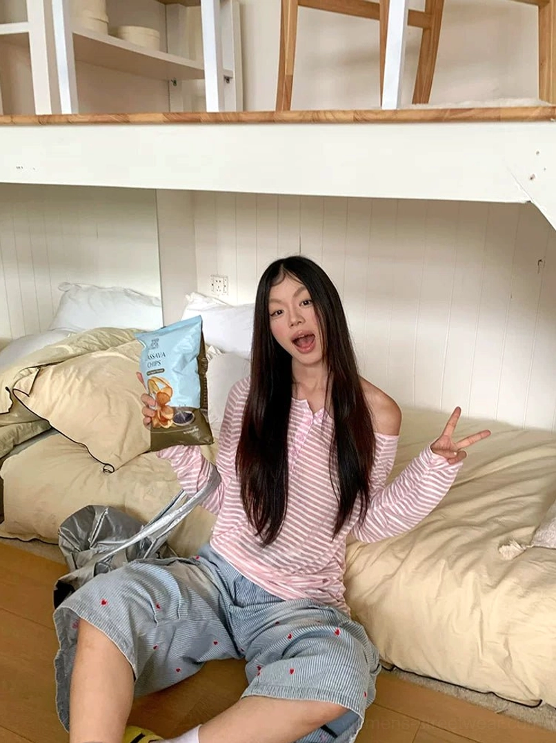 Relaxed pink and white striped off-shoulder long sleeve henley tee styled for Korean streetwear