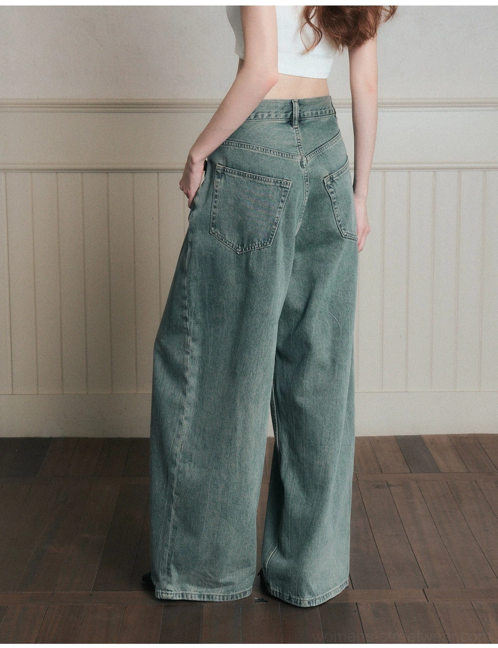 Back three-quarter view of women wearing relaxed vintage wide-leg denim jeans with a soft faded wash and classic rear pockets