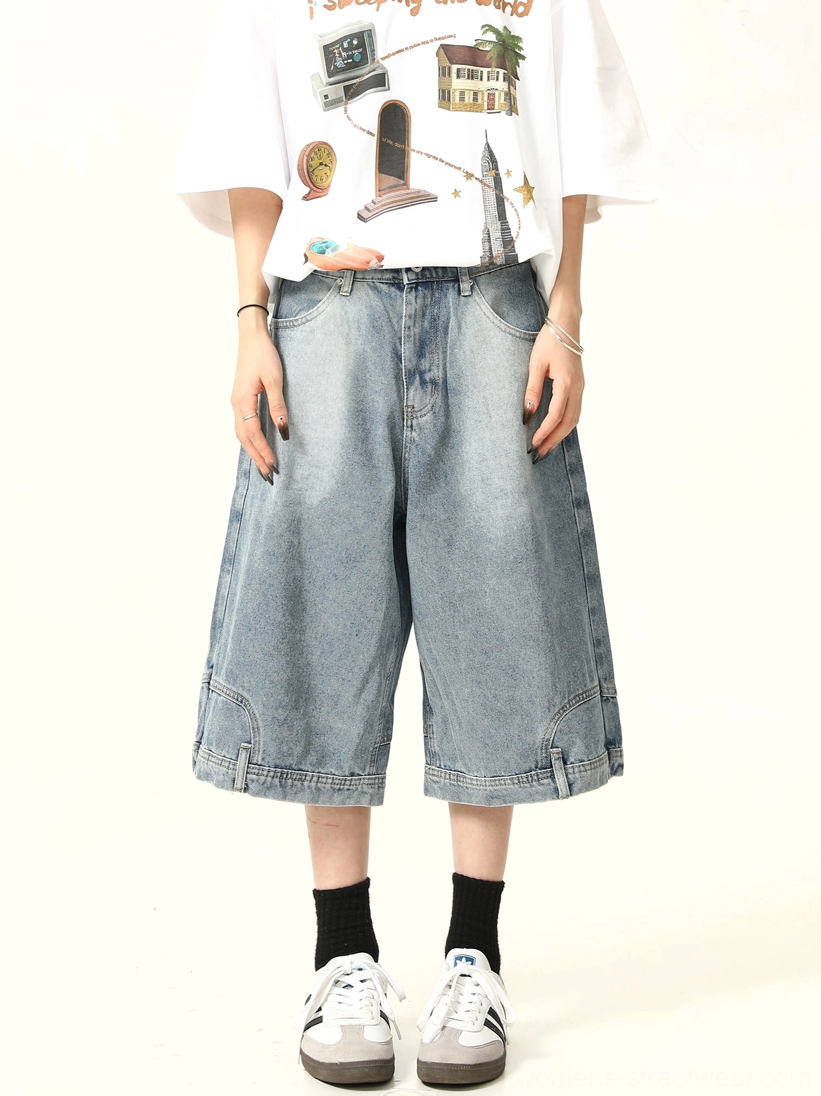 Front half view of relaxed wide-leg denim culotte shorts with clean denim texture, neat cropped hem, graphic white tee, and vintage sneakers
