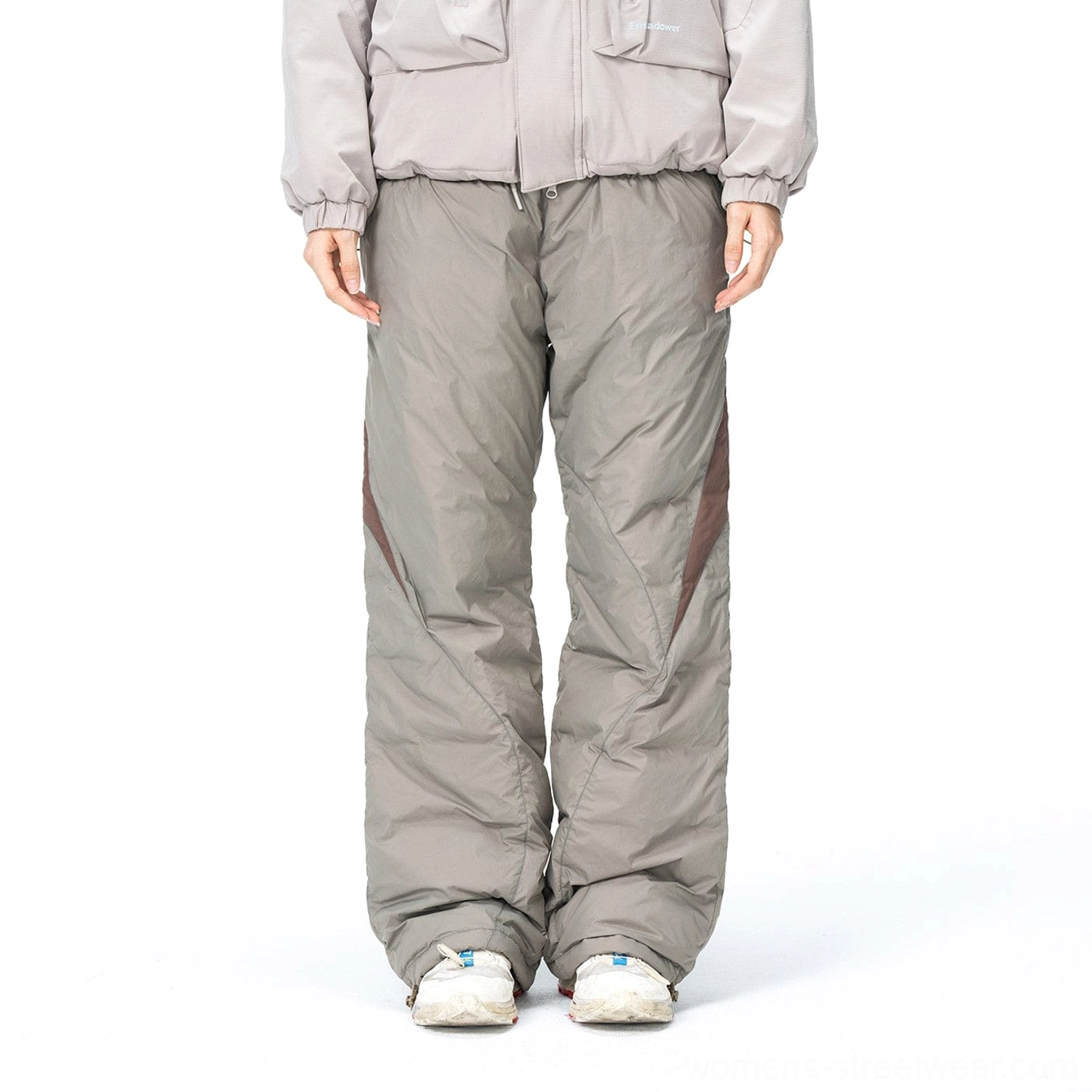 Front view of relaxed taupe gray padded streetwear pants with contrasting panels and wide-leg silhouette