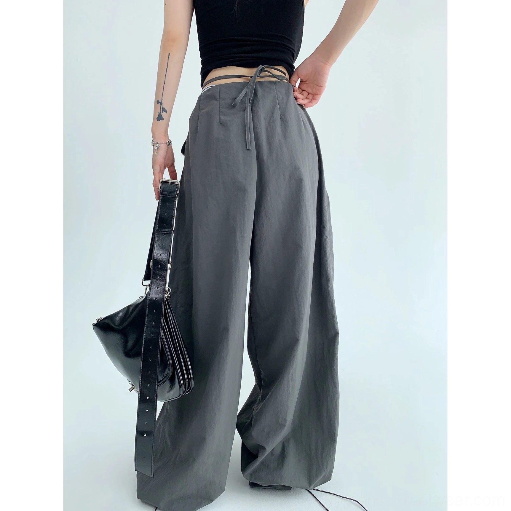 Relaxed wide-leg streetwear pants in black and dark gray with fluid drape and utility-inspired parachute styling