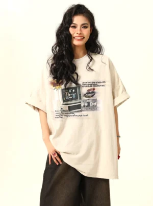 Apricot beige retro arcade graphic oversized T-shirt for women styled with dark wide-leg pants front view