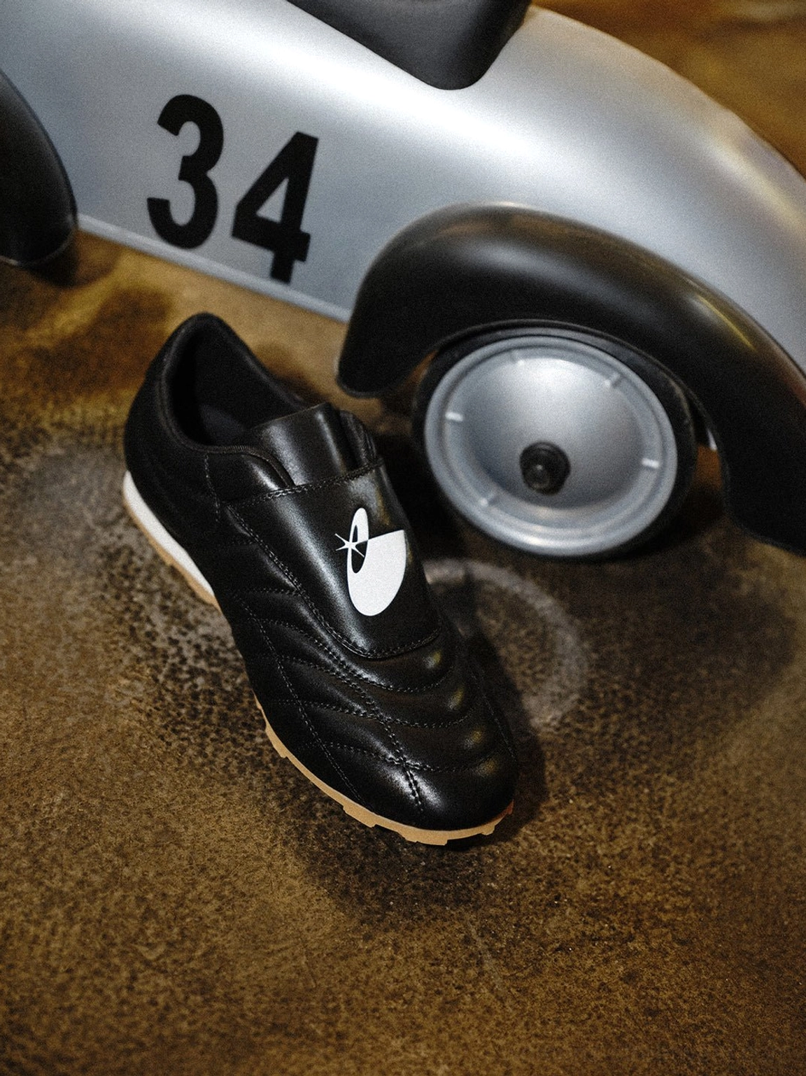 Retro black soccer trainer sneakers with quilted leather-style panels and contrasting gum sole for streetwear outfits
