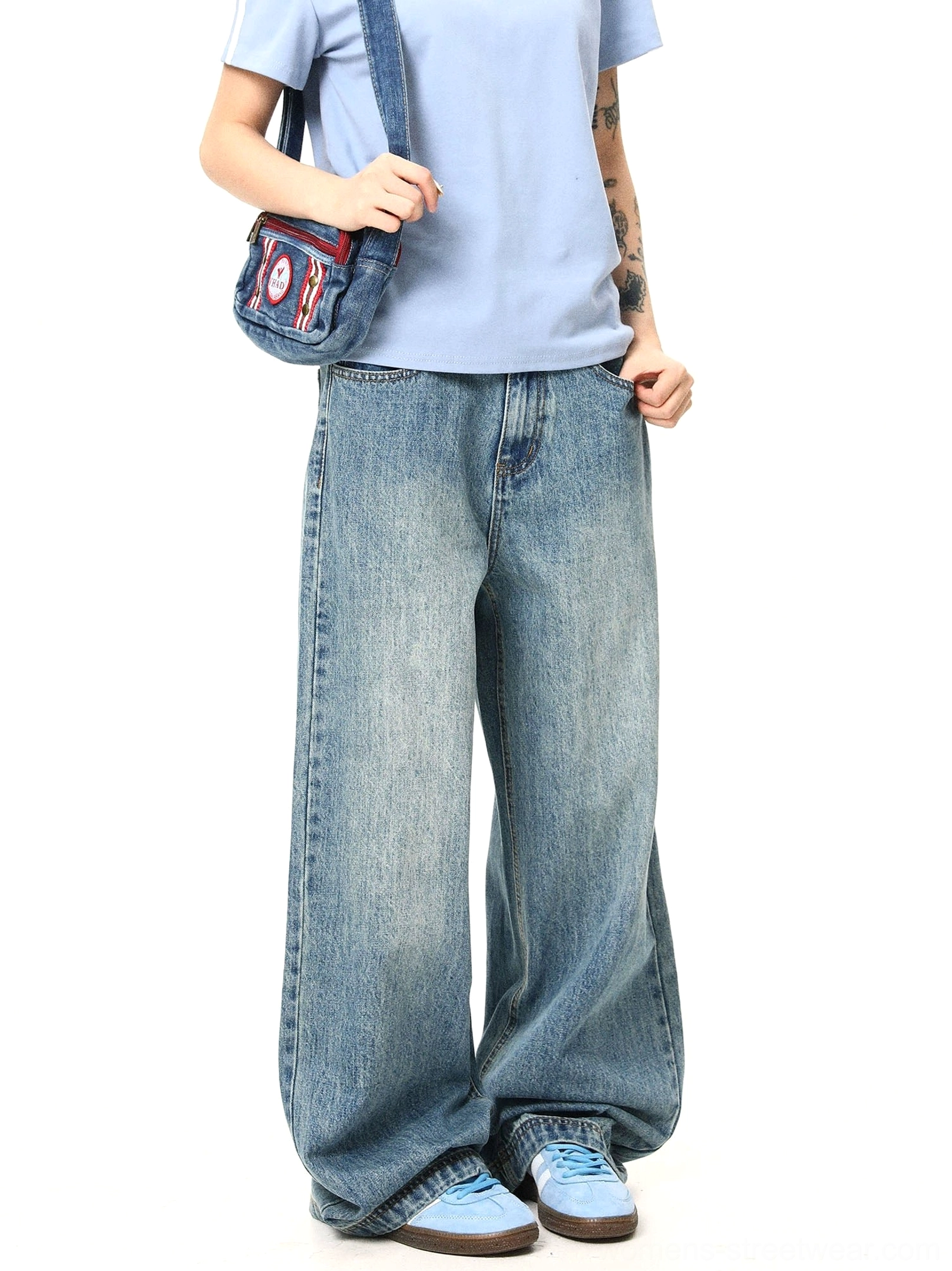 Front full-body view of retro blue baggy jeans showing the loose wide-leg silhouette, waistband, and zipper fly