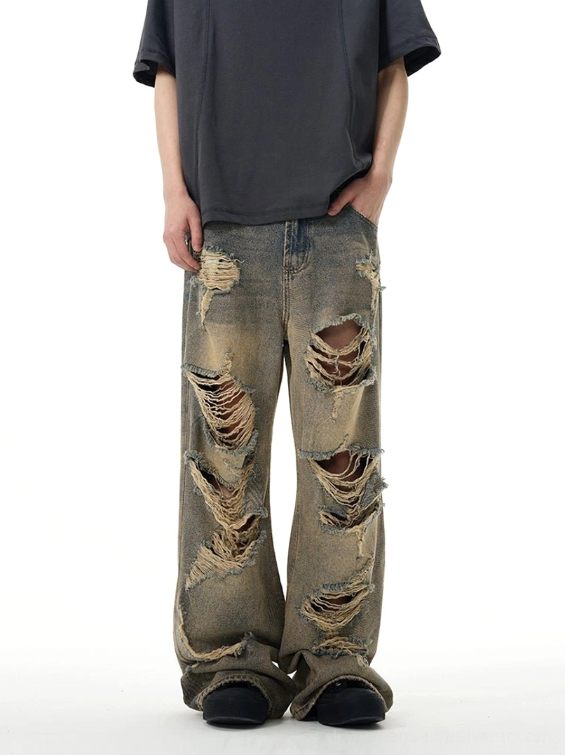 Front low angle view of retro blue distressed wide-leg ripped jeans styled with an oversized dark streetwear t-shirt