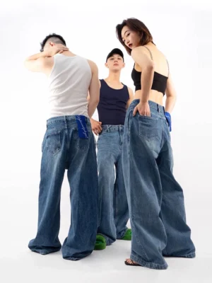 Three models wearing retro blue ultra wide-leg denim jeans in a rear three-quarter studio view with relaxed Y2K streetwear styling