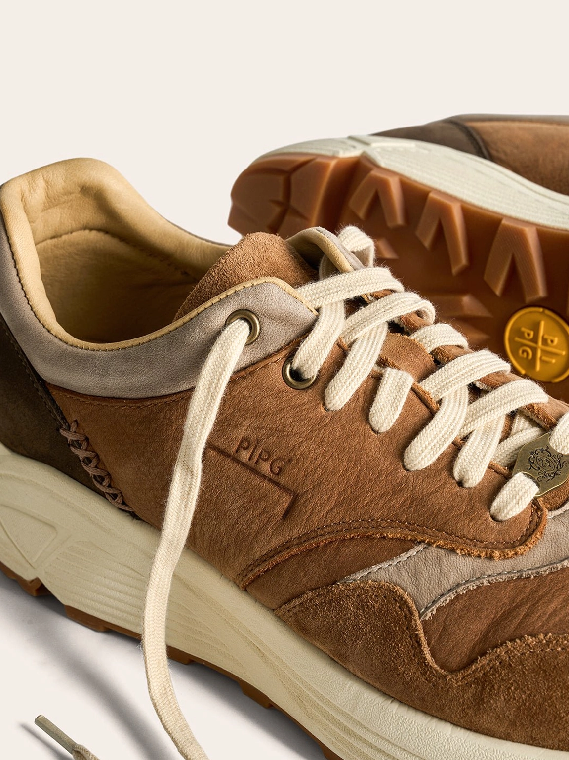 Retro brown running shoes with tonal suede texture and sculpted cream midsole for everyday wear