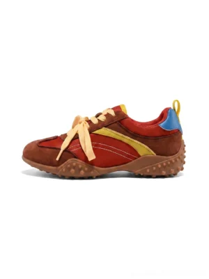 Side view of women's retro colorblock low-profile trainers in coffee brown suede-textured panels with red fabric, ochre yellow and blue accents, wide yellow laces and a textured rubber outsole