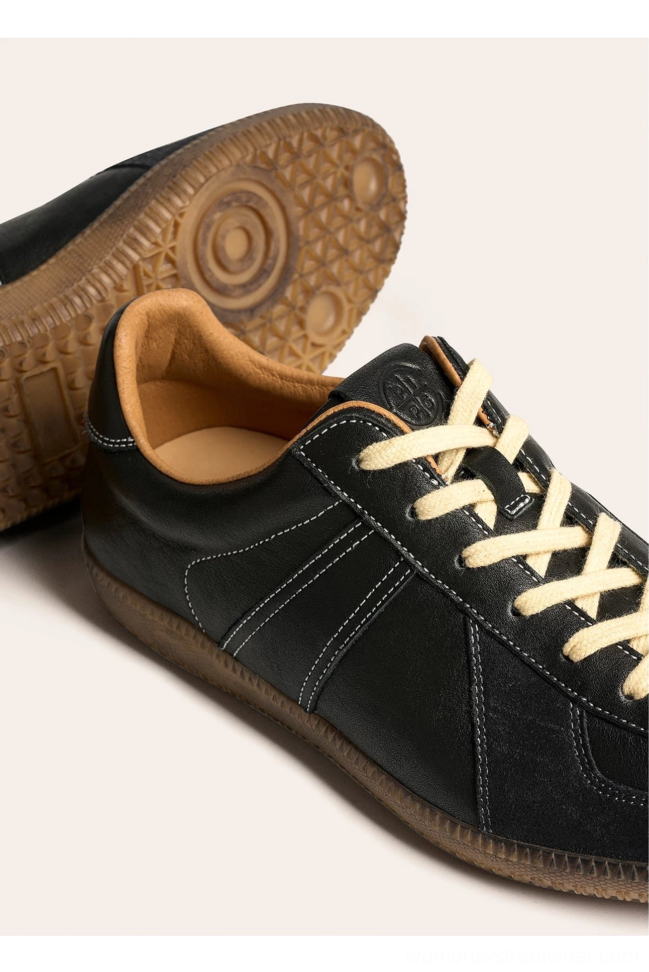 Black retro German army leather sneaker close-up with detailed topstitching and brown gum rubber outsole