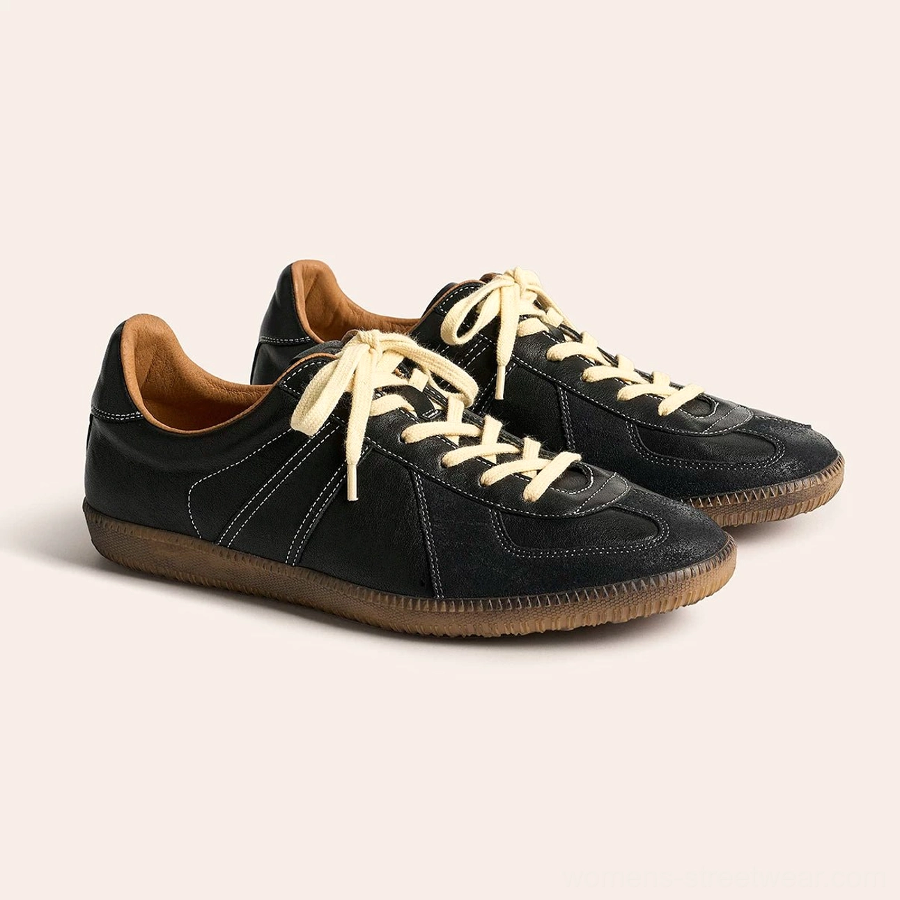 Pair of black retro German army leather sneakers with cream laces and classic brown gum soles overhead view