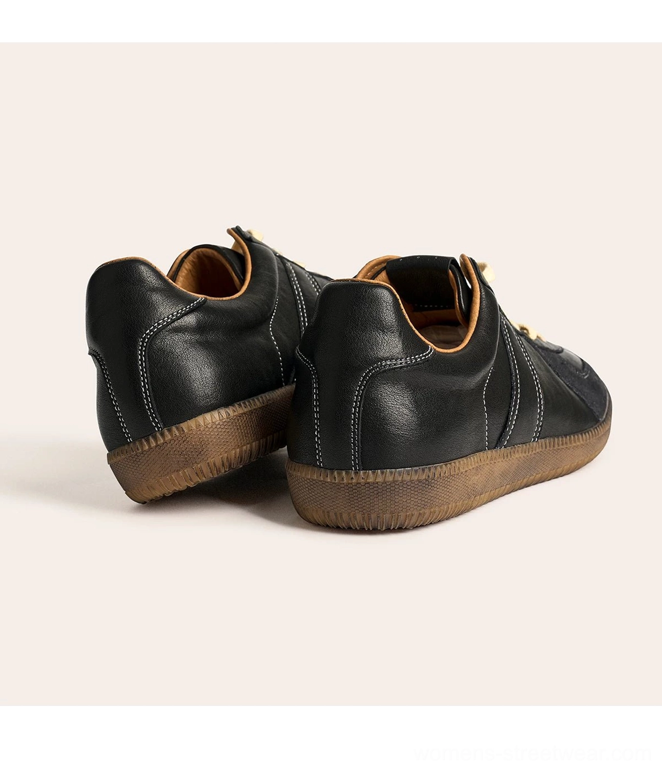 Rear view of black retro German army leather sneakers showing padded heel construction, topstitching, and gum outsoles