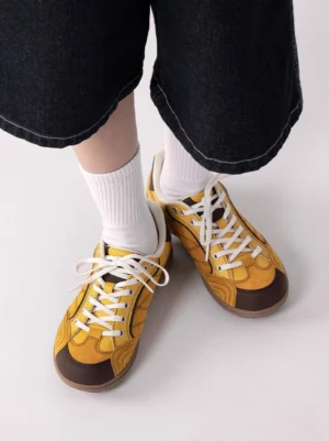 Top-down lifestyle wear view of vintage colorblock German trainer sneakers on feet with white crew socks and black denim, showing coordinated streetwear styling