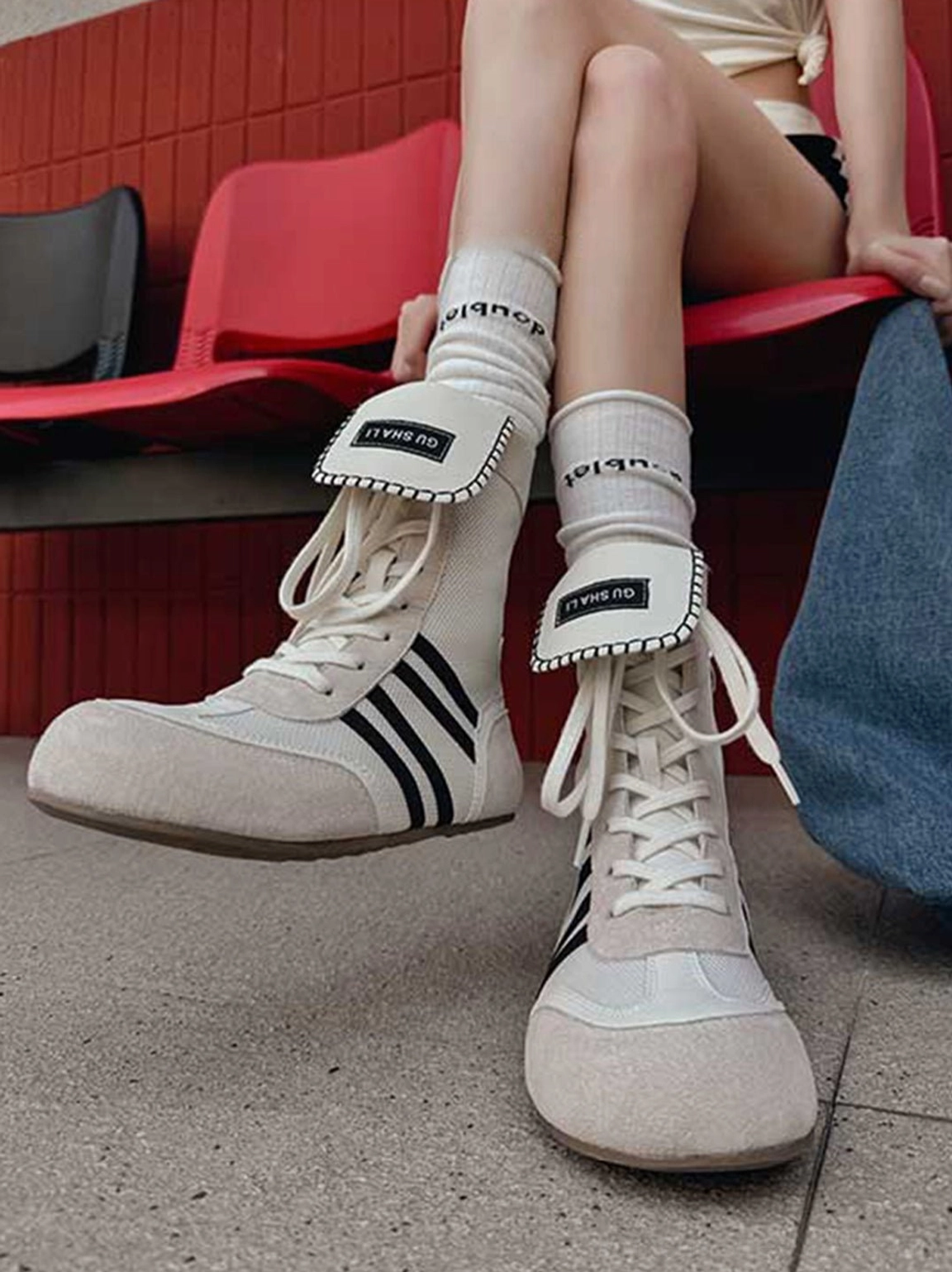 Off-white high-top boxing trainer boots with black stripes showing fold-down and extended tongue styling options