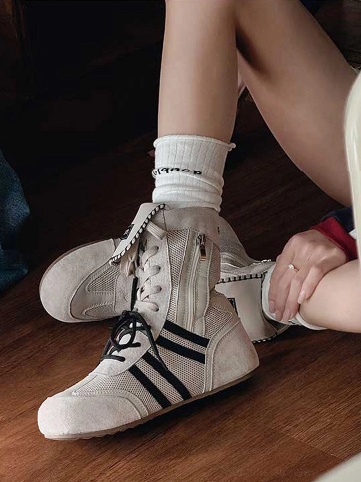 Side view of off-white and black high-top boxing trainer boots showing side zipper, breathable mesh panels, and lace-up closure