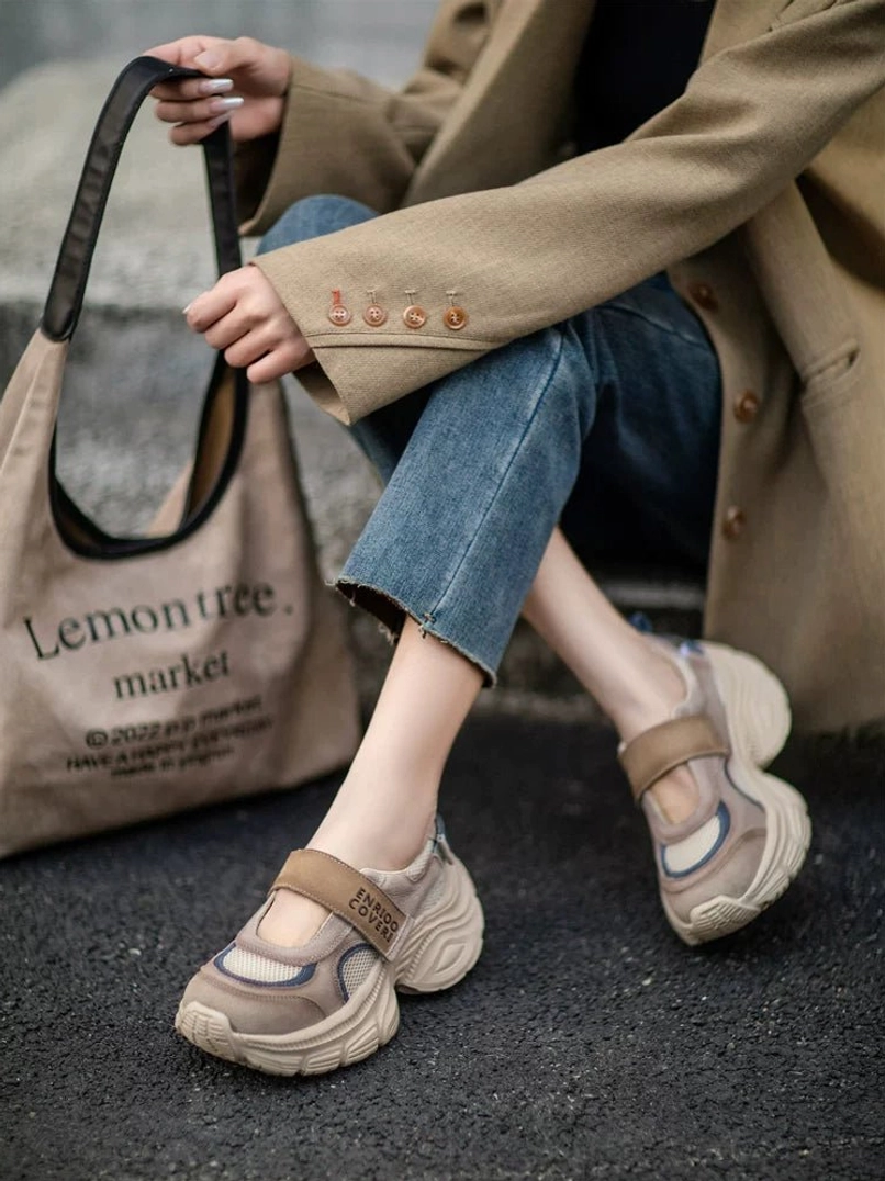 Retro Mary Jane platform sneakers in a streetwear outfit showing tan printed hook and loop strap, khaki upper, off-white sole, and sculpted chunky platform construction