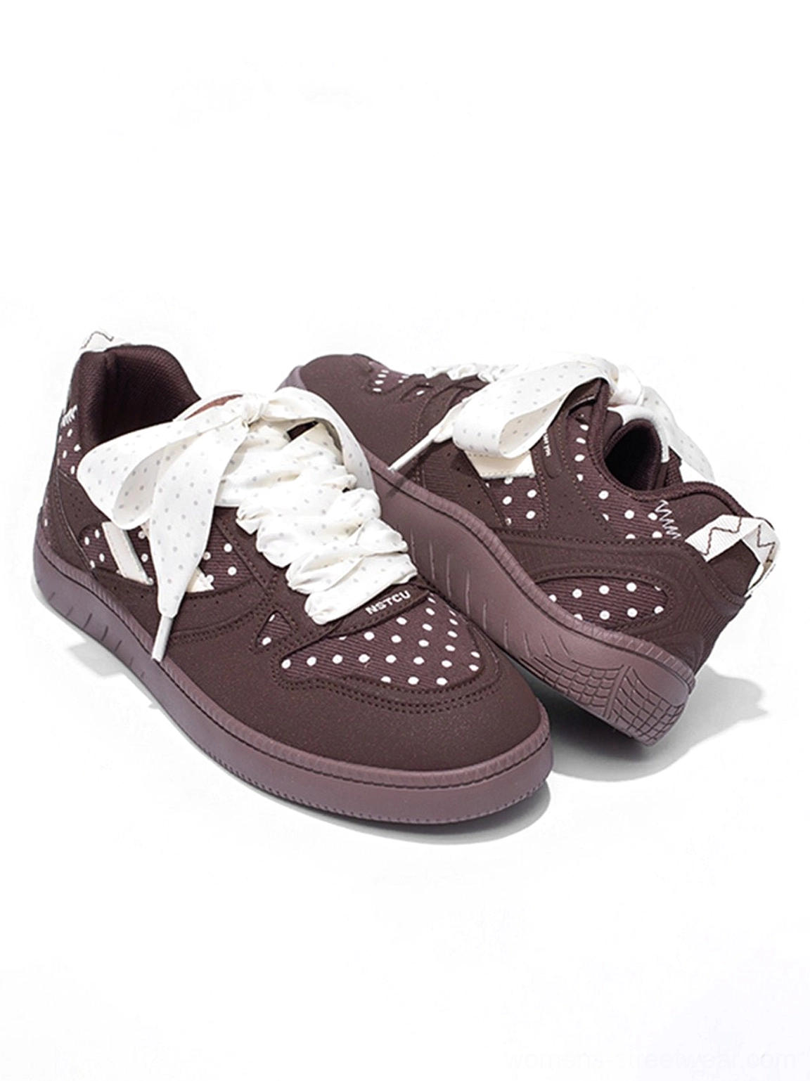 Retro polka dot skate sneakers with decorative ribbon laces and a grounded platform-style flat sole