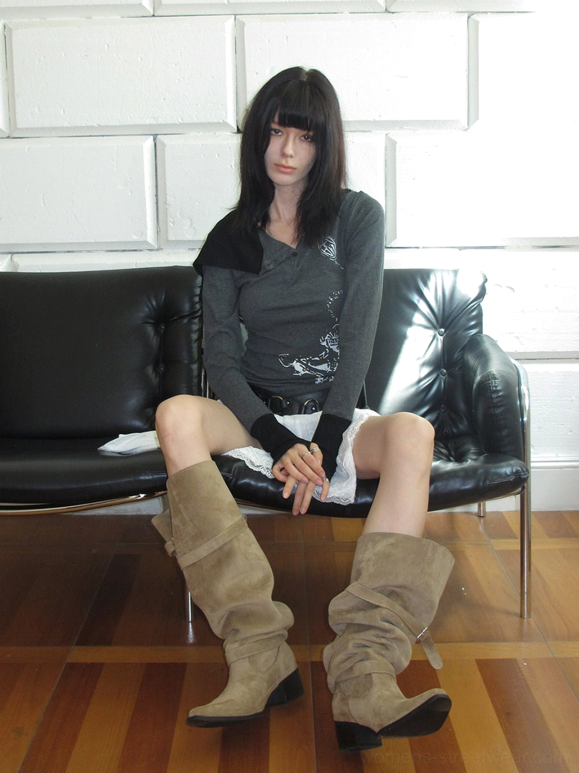 Khaki retro suede-look slouch riding boots styled with dark layered clothing showing buckle accents and tall shaft