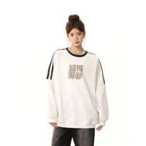 Front medium full-body view of beige gray retro three-stripe embroidered crewneck sweatshirt with black shoulder stripes colorful chest embroidery and contrast ribbed cuffs