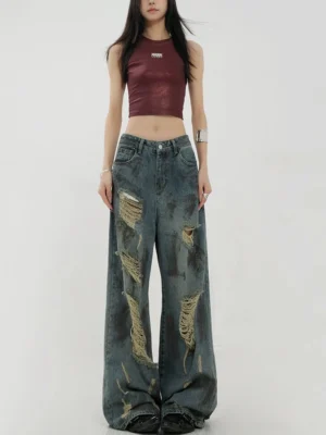 Front full-body view of women's retro blue tie-dye distressed wide-leg jeans with washed vintage denim and frayed ripped details