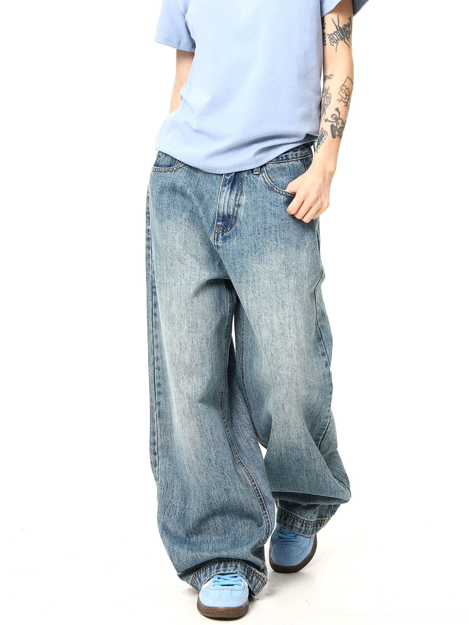 Side walking view of relaxed wide-leg vintage washed denim jeans showing natural fabric creases and streetwear volume