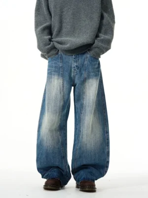 Front view of vintage faded blue wide-leg denim jeans styled with an oversized grey knit sweater for relaxed streetwear fashion