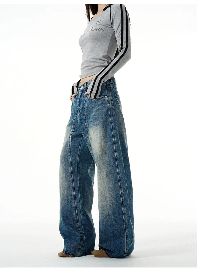 Left side view of relaxed blue wide-leg denim jeans with a classic waistband, loose leg shape, and faded vintage finish