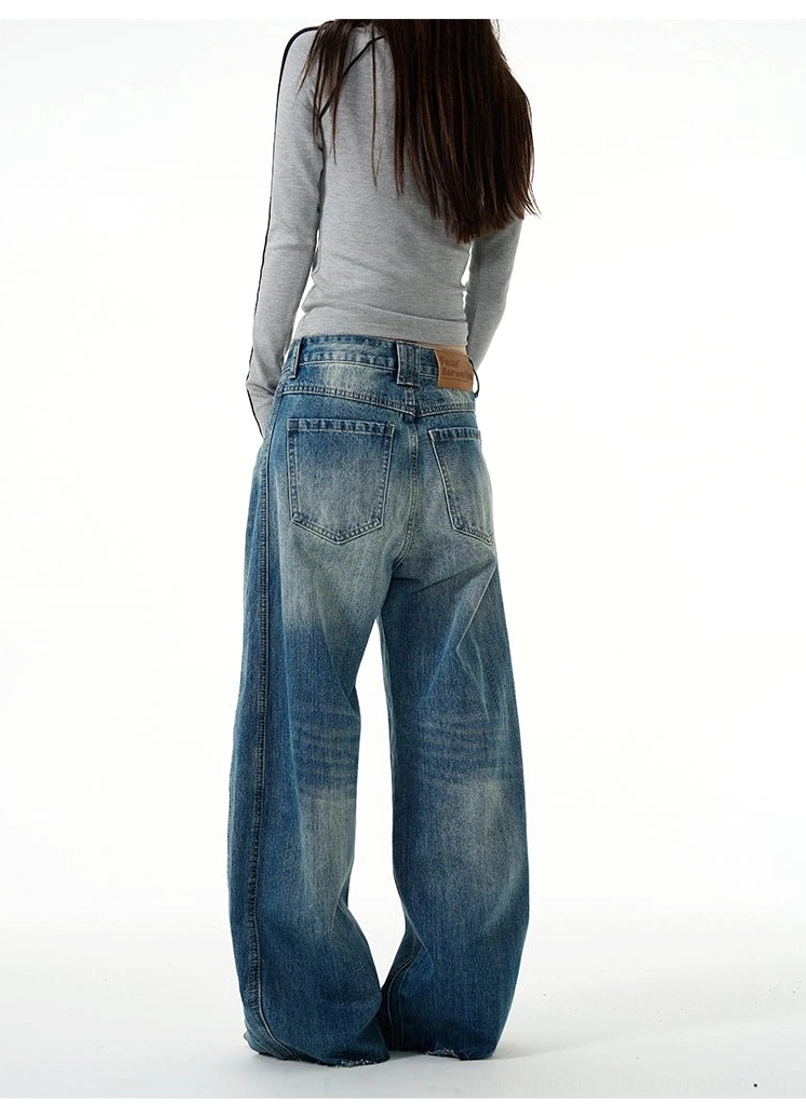 Rear full-body view of retro washed blue wide-leg jeans showing the stitched back pockets and relaxed streetwear silhouette
