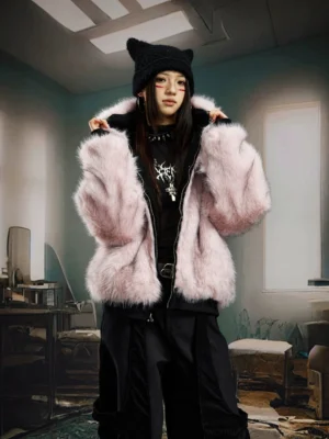 Female model wearing a blush pink reversible faux fur hooded bomber jacket in an oversized Korean streetwear outfit