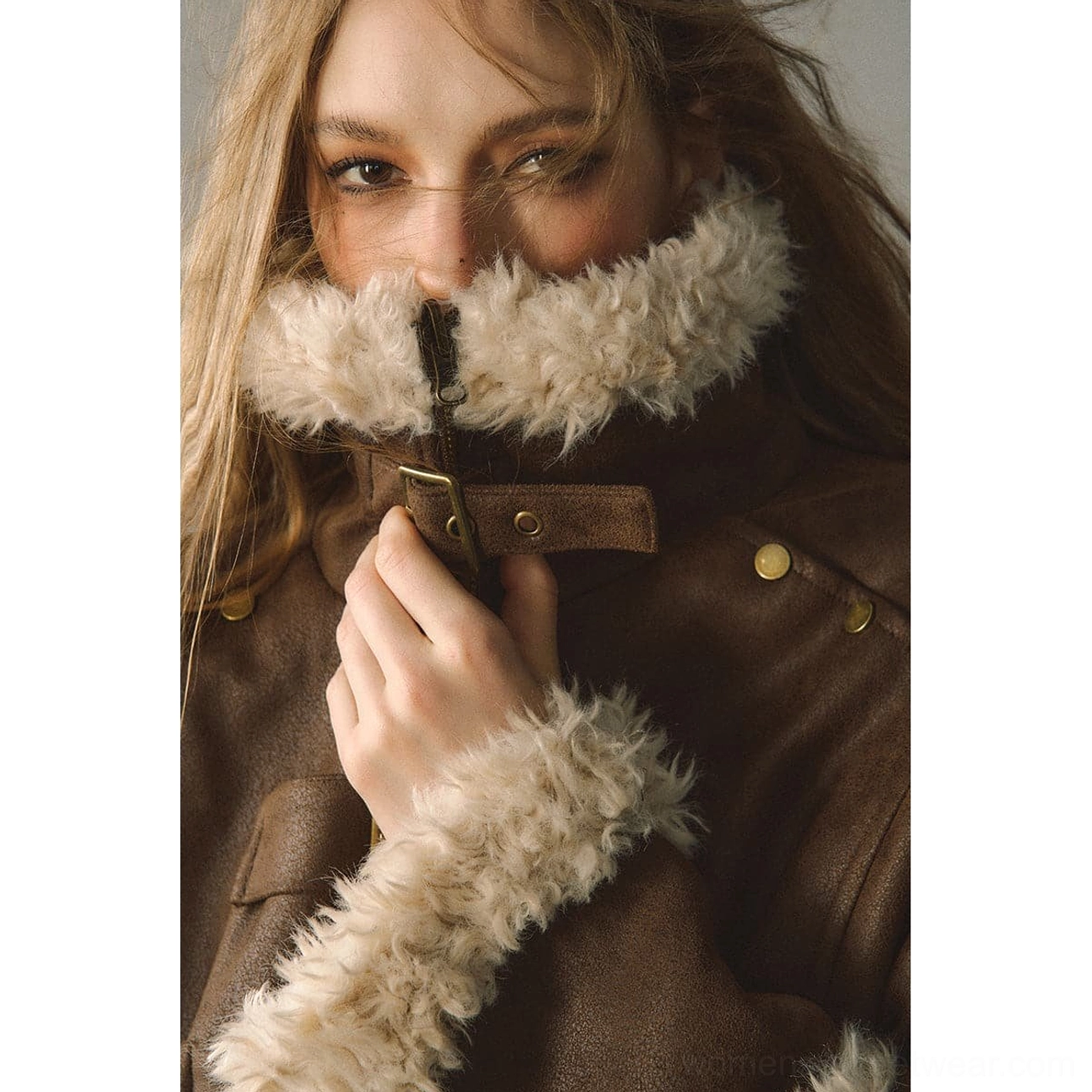 Close-up of reversible suede shearling jacket neckline with plush cream collar, zipper, snap buttons, suede texture, and vintage metal hardware