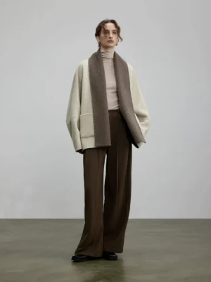 Full body front view of off-white reversible two-tone wool silk oversized cardigan styled with brown wide-leg trousers