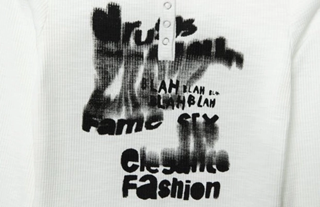 Close-up of ribbed fabric and blurred black graffiti letter print on Y2K Henley crop top