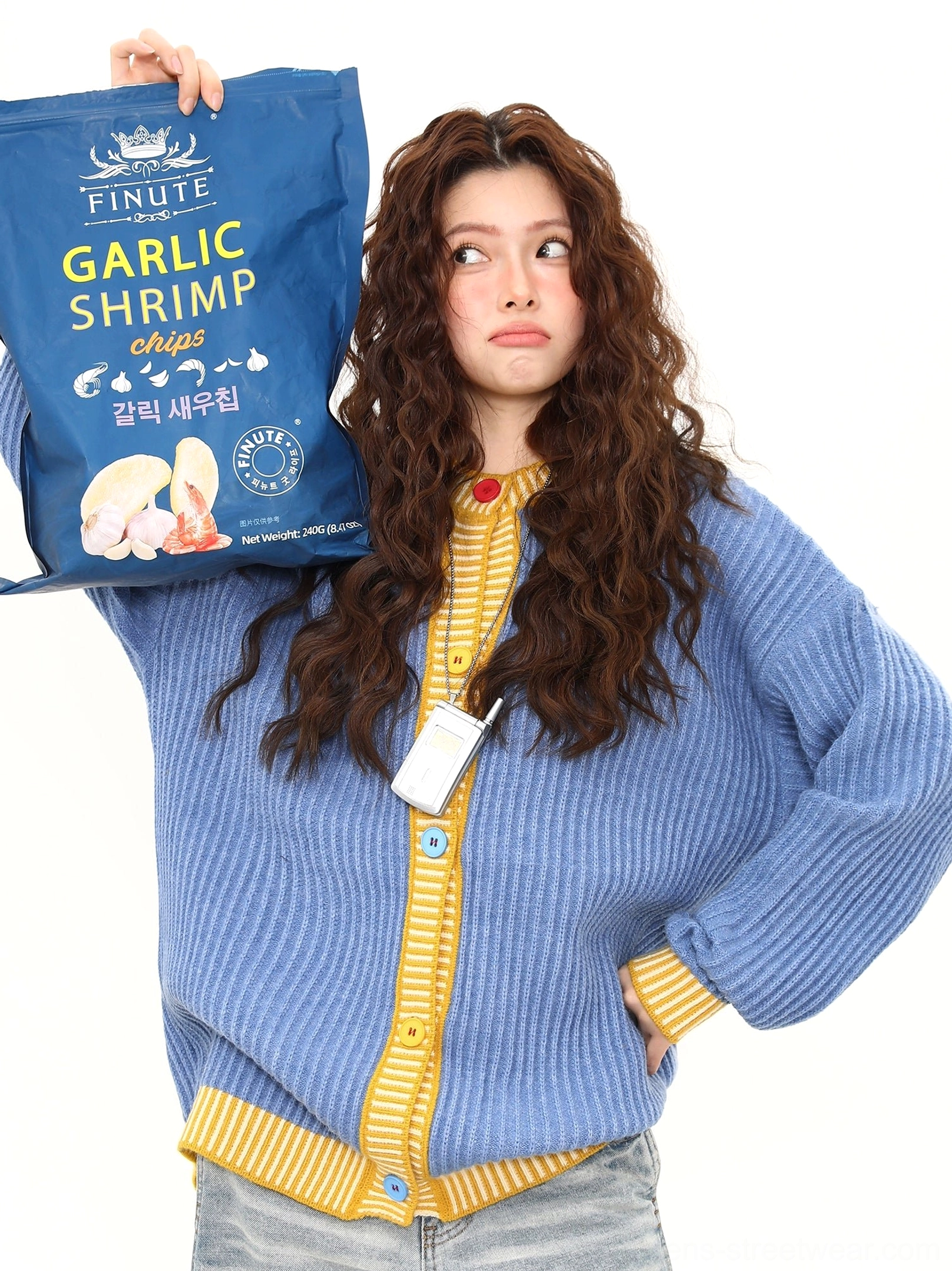 Close up of ribbed sky blue cardigan texture, yellow striped trim, round buttons, and oversized front placket