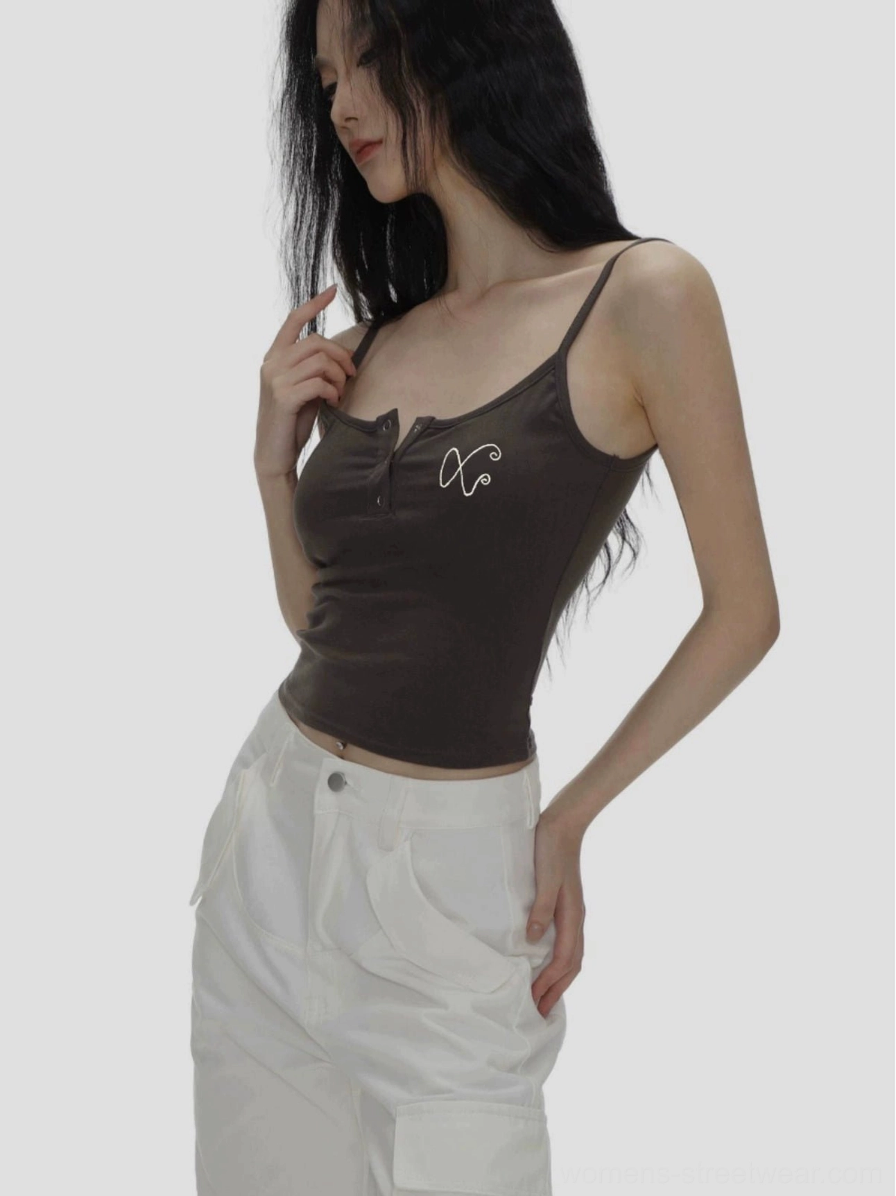 Dark brown ribbed spaghetti strap camisole with Henley button neckline and XO chest embroidery styled with white wide leg trousers