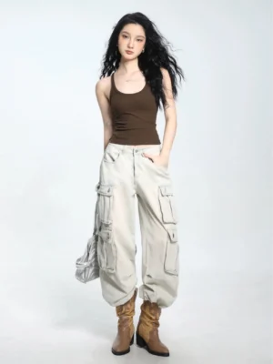 Dark coffee ribbed spaghetti strap fitted cropped camisole paired with light gray cargo jeans and boots
