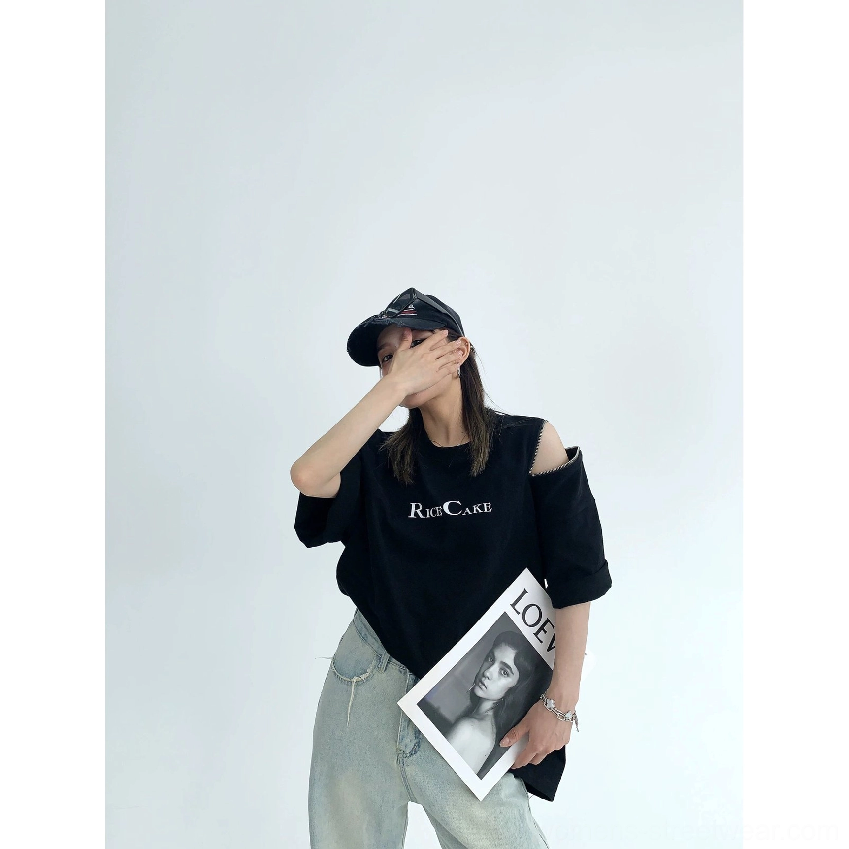Side view of black RICE CAKE oversized graphic tee with open zip shoulder cutout and relaxed streetwear fit