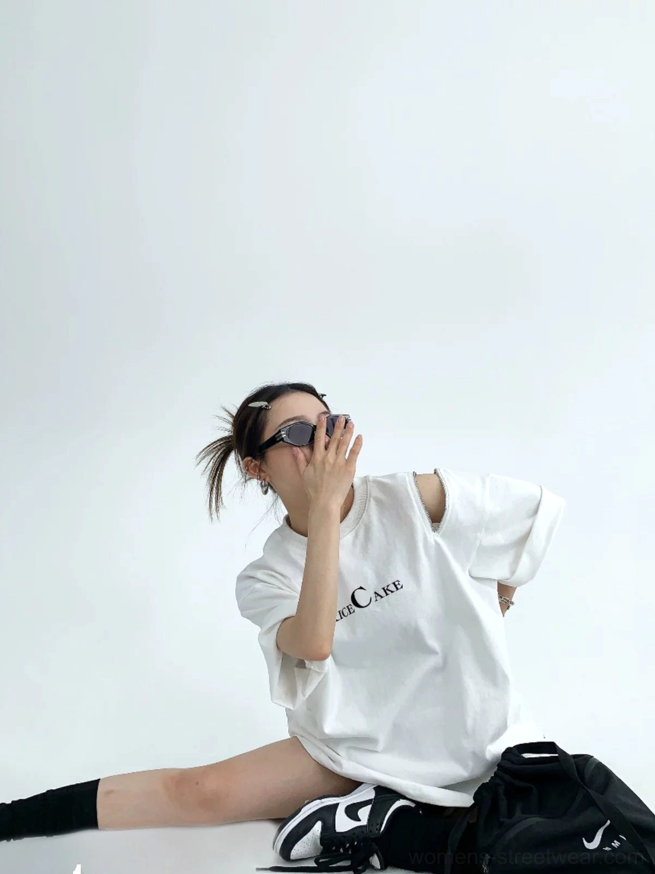 White RICE CAKE oversized streetwear tee with an open zip shoulder cold-shoulder detail in a seated outfit